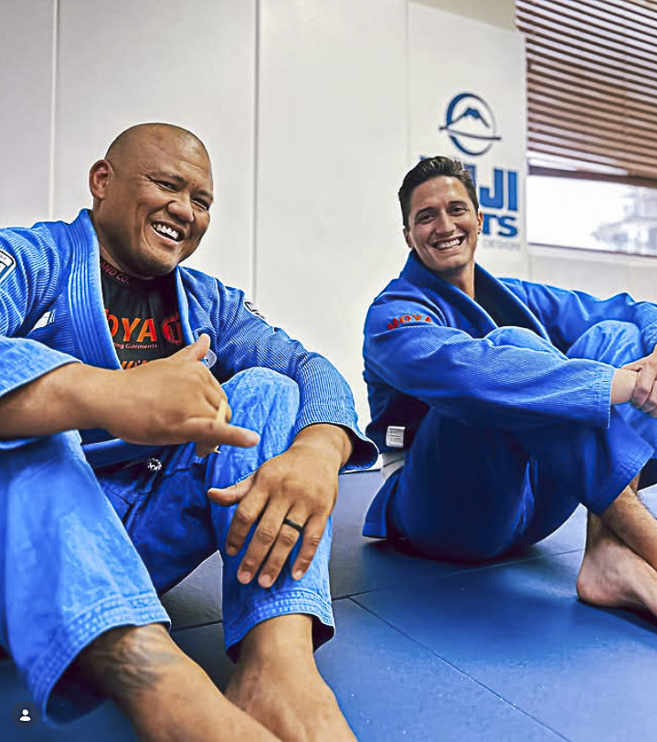 Two adult students smiling on the mats at Cove Jiu Jitsu